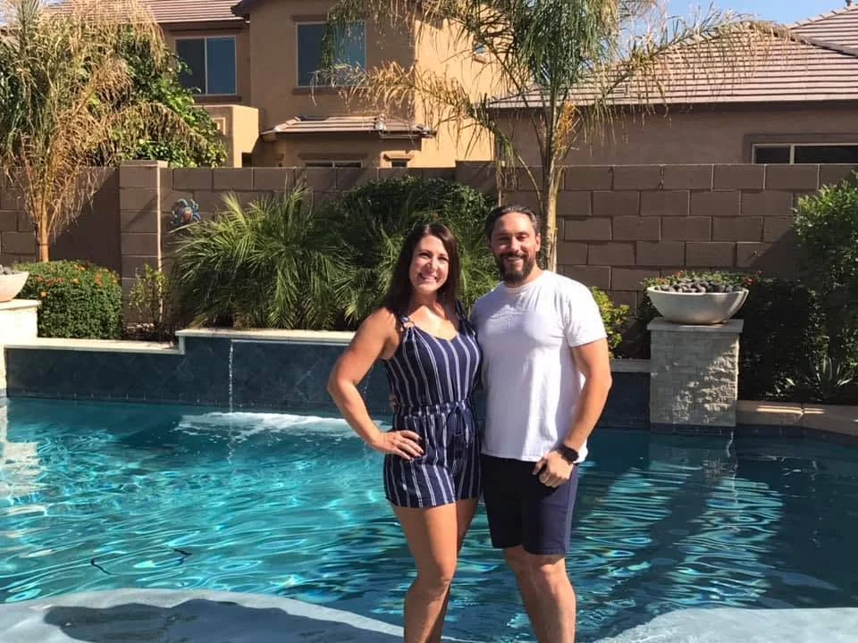 Two people beside a swimming pool